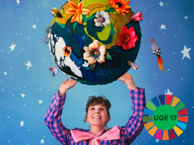 Roselil løfter en bold dekoreret som en jordklode med blomster