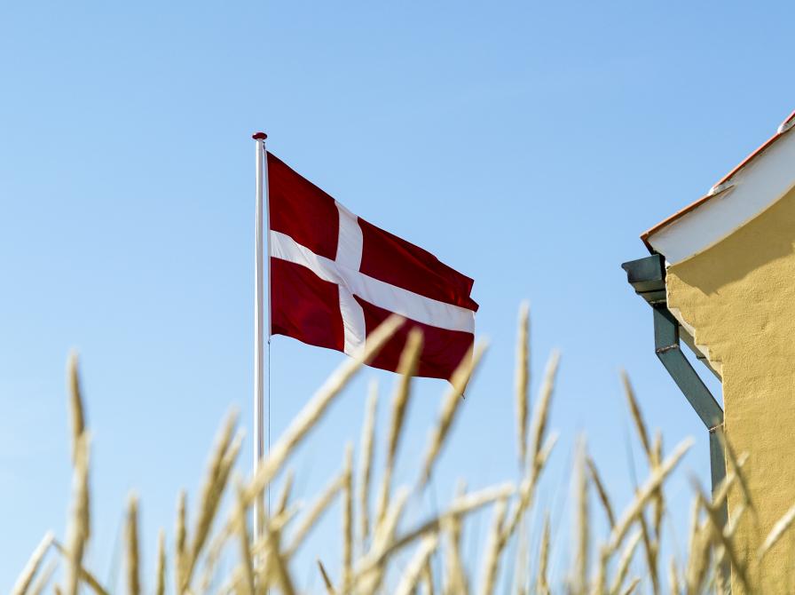 Dansk flag ses mod en lys blå himmel