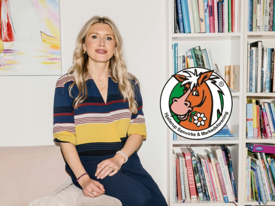 Aida Bikic sidder på sofa til venstre for en bogreol.